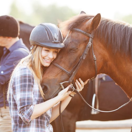 Woman hugging horse and expressing joy and heppines